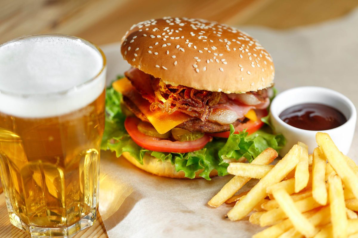 Big,tasty,burger,and,fries,with,beer,on,foreground,on